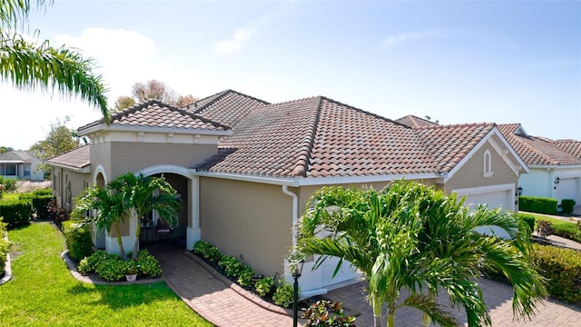 1503 Calle Grand St, Bradenton, FL 34209 - mediterranean / spanish house featuring stucco siding, a garage, a tile roof, and a front yard