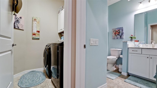 1503 Calle Grand St, Bradenton, FL 34209 - bathroom with washing machine and dryer, tile patterned flooring, vanity, toilet, and baseboards