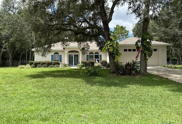 view of front of property with a garage, stucco siding, fence, a front yard, and driveway