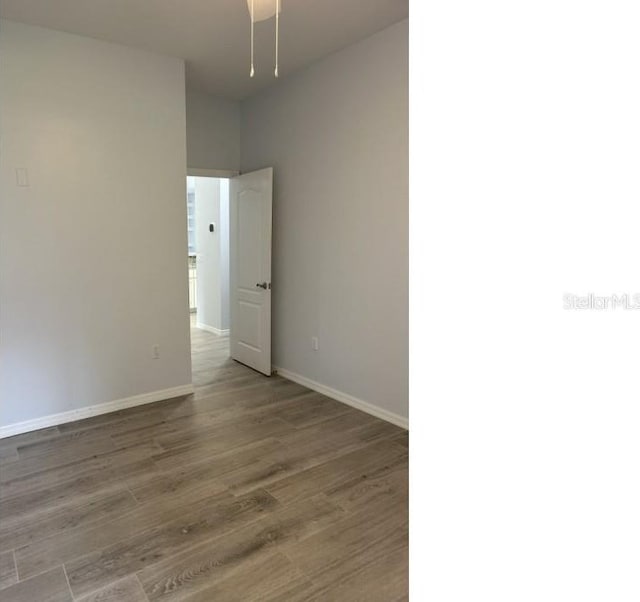 spare room featuring wood finished floors and baseboards