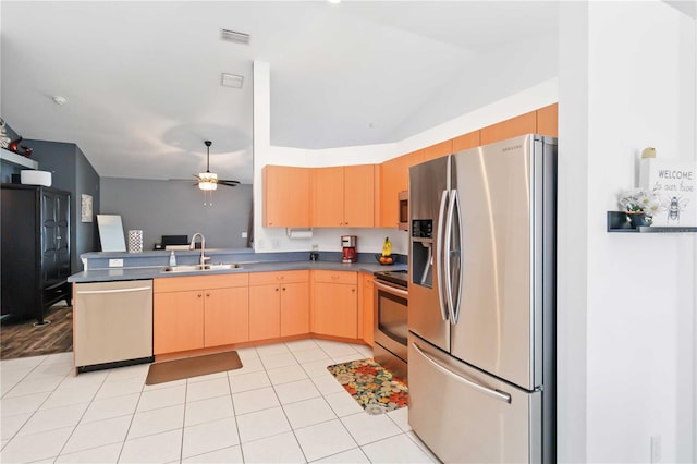 kitchen featuring appliances with stainless steel finishes, a sink, light brown cabinetry, a peninsula, and ceiling fan