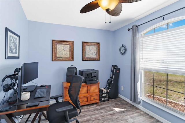 office with healthy amount of natural light, ceiling fan, light wood-type flooring, and baseboards
