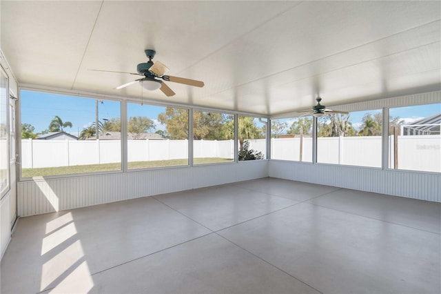 unfurnished sunroom featuring ceiling fan and plenty of natural light