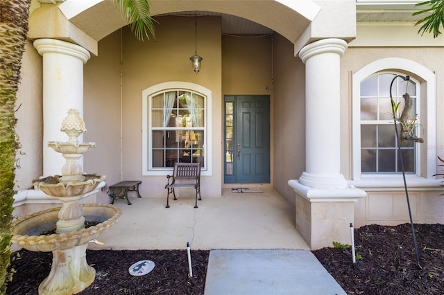 property entrance featuring stucco siding and a porch