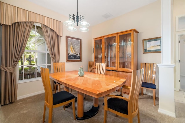 carpeted dining area featuring healthy amount of natural light, a chandelier, baseboards, and ornate columns