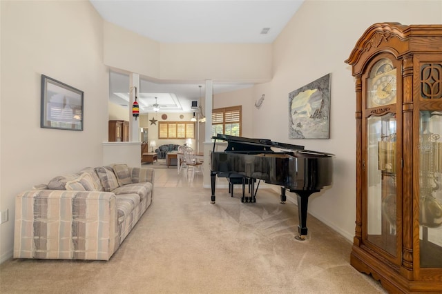 carpeted living room featuring a ceiling fan and baseboards