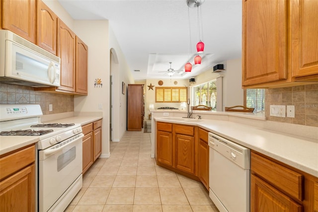 kitchen featuring white appliances, a sink, light tile patterned floors, light countertops, and tasteful backsplash
