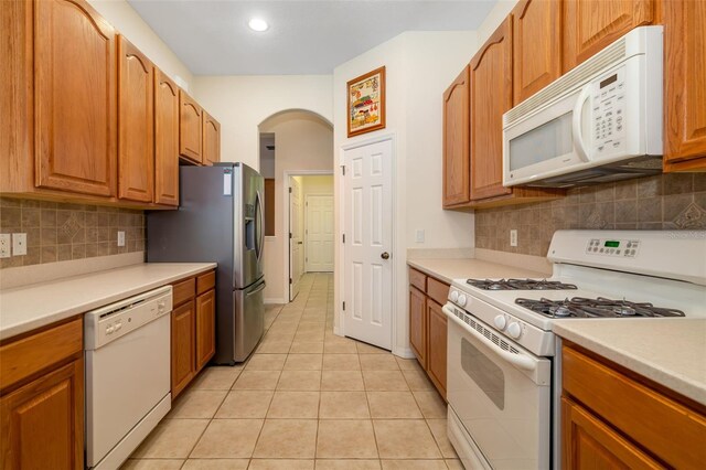 kitchen featuring white appliances, light tile patterned floors, light countertops, tasteful backsplash, and recessed lighting