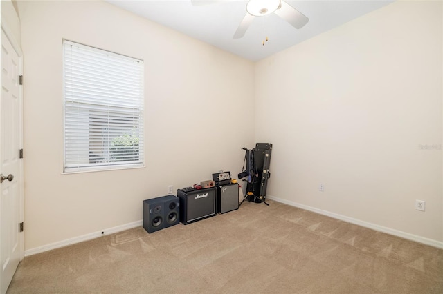 miscellaneous room with light carpet, ceiling fan, and baseboards