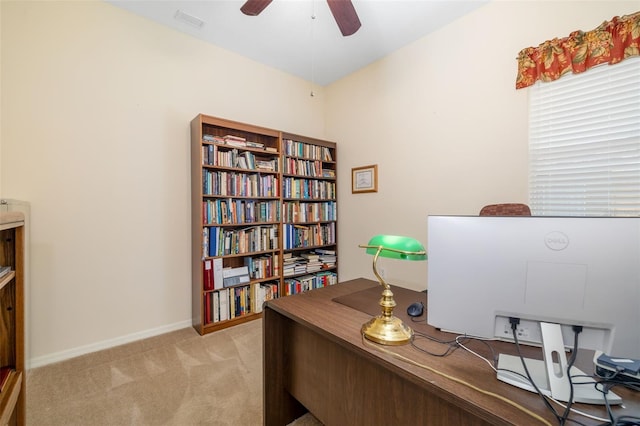 office space featuring light colored carpet, a ceiling fan, and baseboards