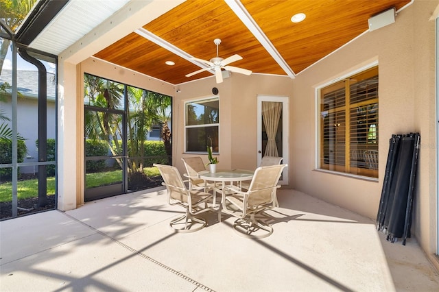 sunroom / solarium featuring wooden ceiling, a ceiling fan, outdoor dining area, plenty of natural light, and recessed lighting