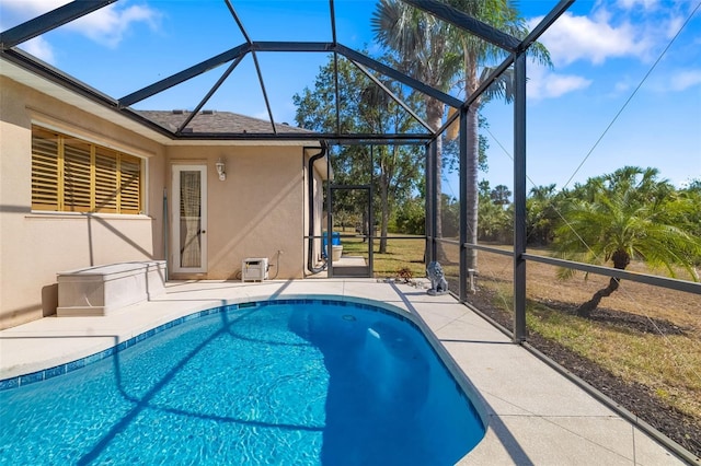 swimming pool with a patio and glass enclosure