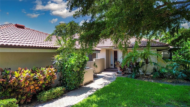 4812 Kestral Park Cir Unit 20, Sarasota, FL 34231 - view of front facade with a front lawn, stucco siding, and a tile roof