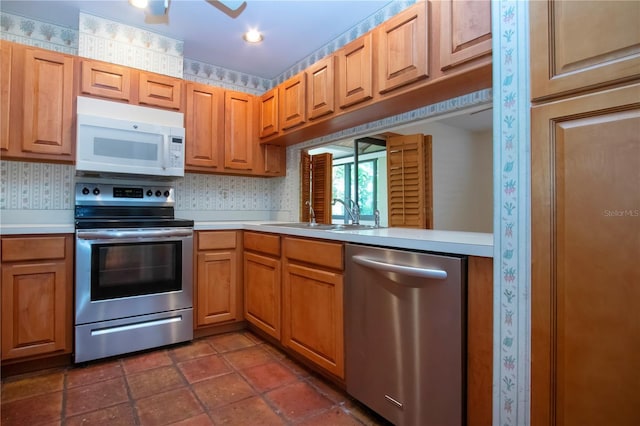4812 Kestral Park Cir Unit 20, Sarasota, FL 34231 - kitchen with a sink, stainless steel appliances, light countertops, and wallpapered walls