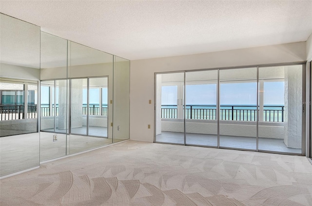 20 Whispering Sands Dr Unit 1201, Sarasota, FL 34242 - carpeted empty room with a water view and a textured ceiling