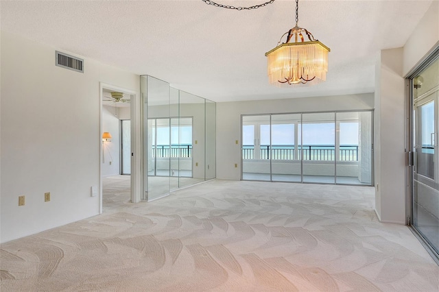 20 Whispering Sands Dr Unit 1201, Sarasota, FL 34242 - empty room with a chandelier, light carpet, and plenty of natural light