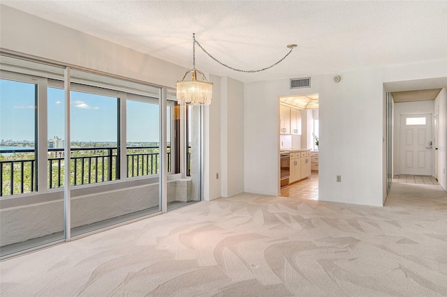 20 Whispering Sands Dr Unit 1201, Sarasota, FL 34242 - empty room with light carpet, a chandelier, and a textured ceiling