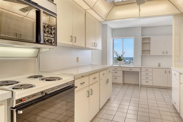20 Whispering Sands Dr Unit 1201, Sarasota, FL 34242 - kitchen featuring black microwave, electric stove, light tile patterned flooring, open shelves, and light countertops