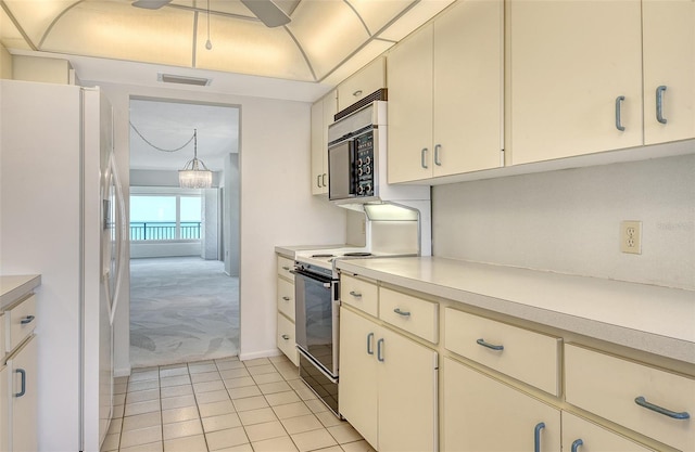 20 Whispering Sands Dr Unit 1201, Sarasota, FL 34242 - kitchen with white fridge with ice dispenser, stainless steel microwave, light colored carpet, range with electric cooktop, and light countertops