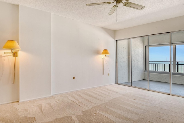 20 Whispering Sands Dr Unit 1201, Sarasota, FL 34242 - unfurnished bedroom featuring carpet flooring, access to outside, a textured ceiling, baseboards, and a ceiling fan