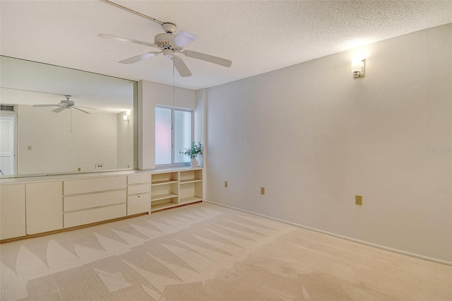20 Whispering Sands Dr Unit 1201, Sarasota, FL 34242 - unfurnished bedroom featuring light colored carpet, a ceiling fan, baseboards, and a textured ceiling