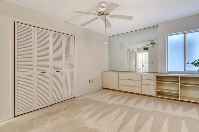 20 Whispering Sands Dr Unit 1201, Sarasota, FL 34242 - unfurnished bedroom with light carpet, a closet, and ceiling fan