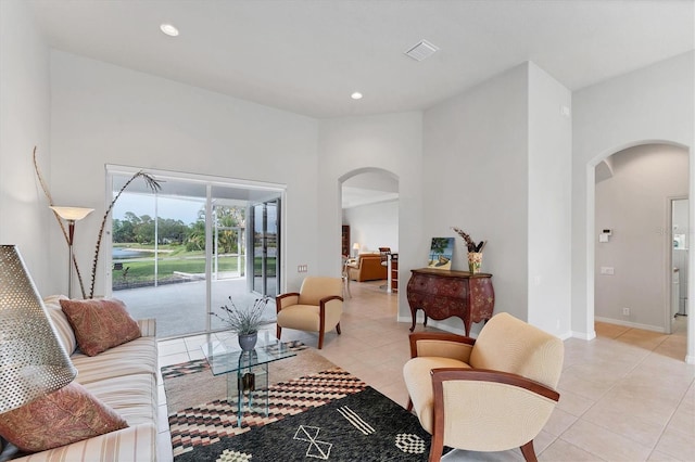1311 Tuscany Blvd, Venice, FL 34292 - living room with arched walkways, light tile patterned flooring, recessed lighting, and baseboards