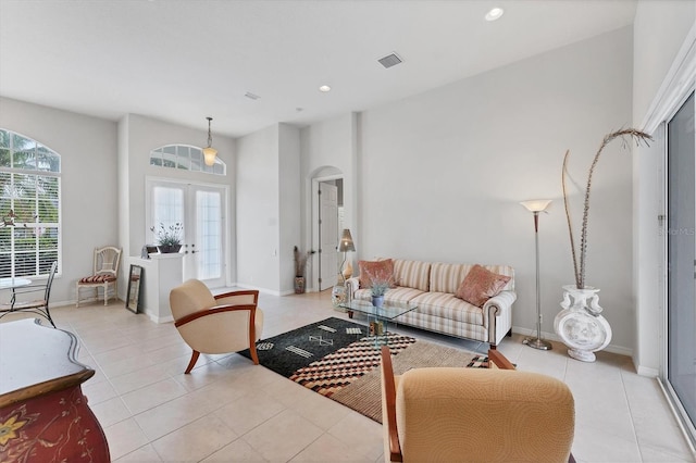 1311 Tuscany Blvd, Venice, FL 34292 - living room featuring arched walkways, light tile patterned floors, recessed lighting, and baseboards