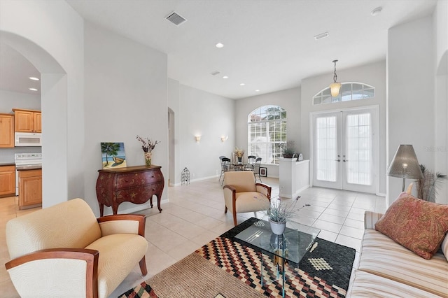 1311 Tuscany Blvd, Venice, FL 34292 - living room featuring arched walkways, light tile patterned flooring, french doors, recessed lighting, and baseboards