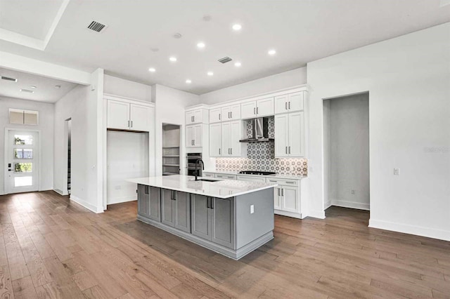 17927 Palmiste Dr, Bradenton, FL 34202 - kitchen with wall chimney exhaust hood, gas cooktop, a sink, an island with sink, and tasteful backsplash
