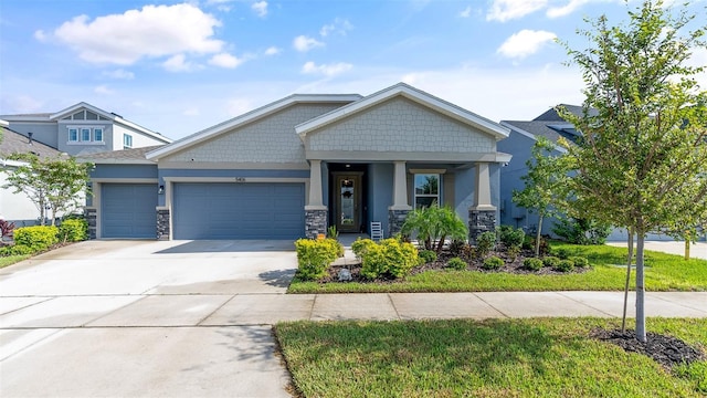 craftsman-style home with concrete driveway, an attached garage, stucco siding, and stone siding