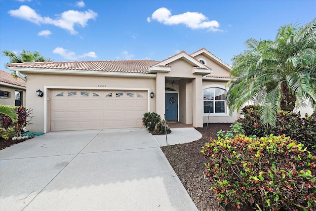 single story home with a tiled roof, stucco siding, driveway, and a garage