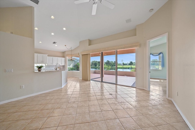 unfurnished living room with a sink, baseboards, ceiling fan, light tile patterned flooring, and recessed lighting