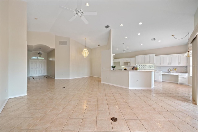 unfurnished living room with high vaulted ceiling, visible vents, light tile patterned flooring, and ceiling fan with notable chandelier