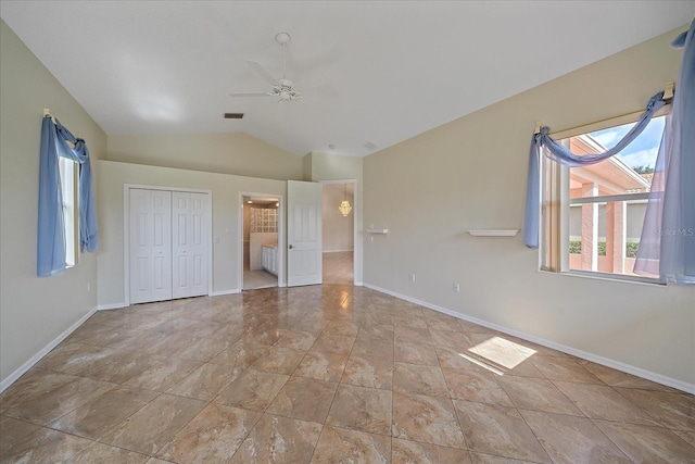 unfurnished bedroom featuring a closet, baseboards, ceiling fan, visible vents, and vaulted ceiling