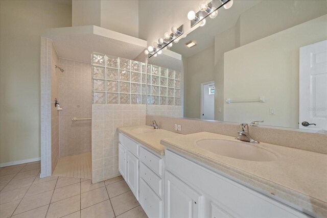 full bathroom featuring tile patterned floors, double vanity, a sink, and a walk in shower