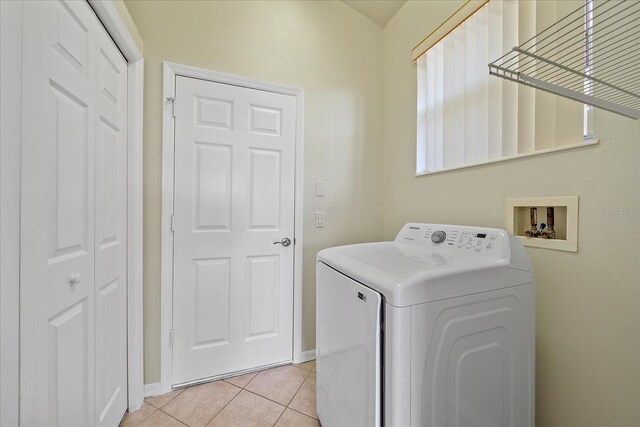 laundry area with laundry area, light tile patterned floors, baseboards, and washer / clothes dryer