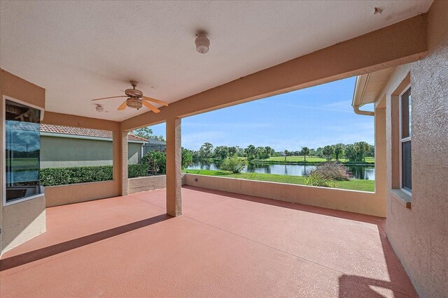 view of patio with a water view and a ceiling fan