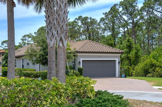 5301 Bartolomeo St, Sarasota, FL 34238 - view of front facade featuring a tile roof, stucco siding, driveway, and an attached garage