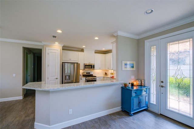 5301 Bartolomeo St, Sarasota, FL 34238 - kitchen with appliances with stainless steel finishes, wood finished floors, white cabinets, light stone counters, and baseboards