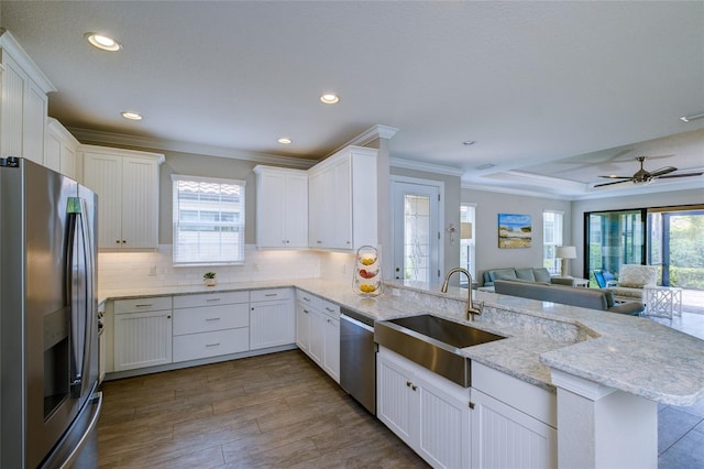 5301 Bartolomeo St, Sarasota, FL 34238 - kitchen featuring stainless steel appliances, open floor plan, a peninsula, crown molding, and healthy amount of natural light