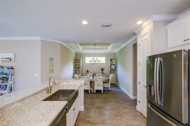 5301 Bartolomeo St, Sarasota, FL 34238 - kitchen featuring stainless steel refrigerator with ice dispenser, white cabinets, a chandelier, crown molding, and pendant lighting