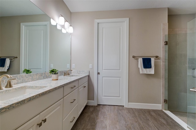 5301 Bartolomeo St, Sarasota, FL 34238 - full bathroom with a shower stall, wood finished floors, double vanity, and baseboards