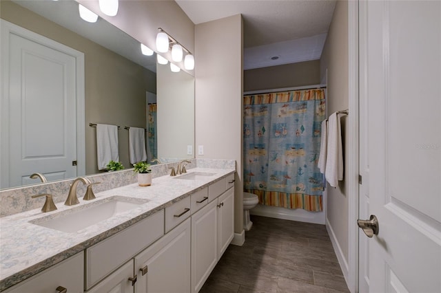5301 Bartolomeo St, Sarasota, FL 34238 - full bath featuring toilet, wood finished floors, double vanity, baseboards, and shower / bath combination with curtain