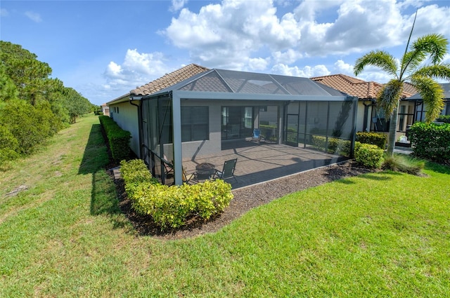 5301 Bartolomeo St, Sarasota, FL 34238 - rear view of house featuring a patio area, a yard, glass enclosure, stucco siding, and a tile roof