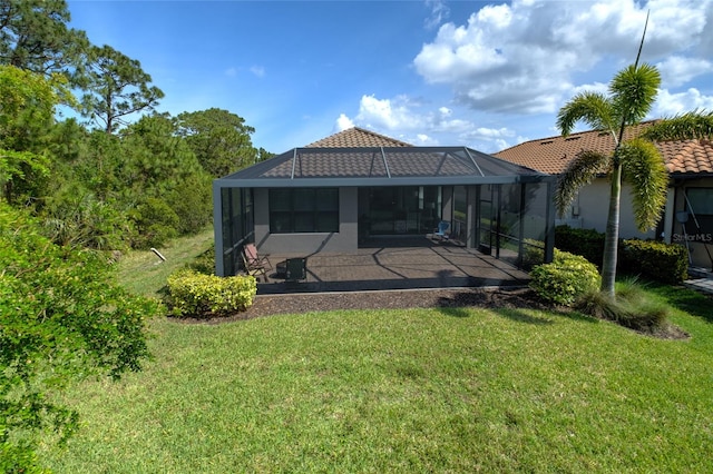 5301 Bartolomeo St, Sarasota, FL 34238 - rear view of house with a patio area, a lawn, a tile roof, a lanai, and stucco siding