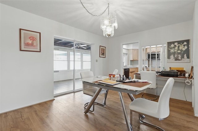3105 Gulfgate Dr, Sarasota, FL 34231 - dining room with wood finished floors, an office area, and a chandelier