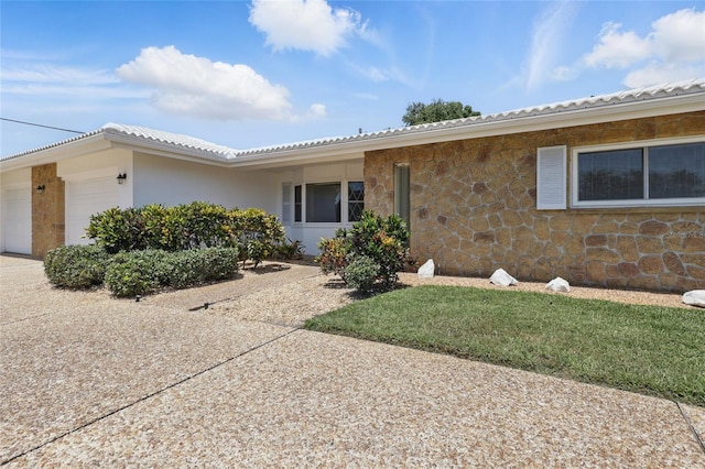 3105 Gulfgate Dr, Sarasota, FL 34231 - single story home with an attached garage, stone siding, and driveway