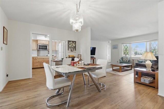3105 Gulfgate Dr, Sarasota, FL 34231 - dining room with light wood-type flooring and a chandelier