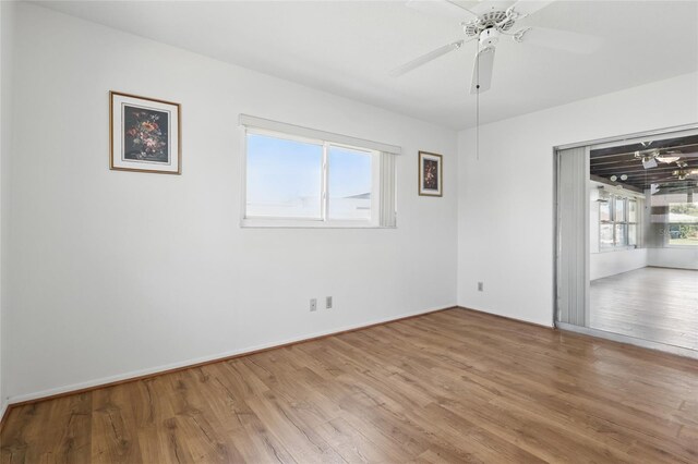 3105 Gulfgate Dr, Sarasota, FL 34231 - empty room with wood finished floors, a ceiling fan, and baseboards